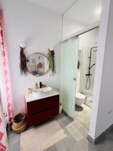 a bathroom with a sink and a mirror and a toilet at Espectacular Casa_Isma in Puerto Real