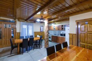a dining room with a table and chairs and a kitchen at CONACUL DE SUB MUNTE in Novaci-Străini