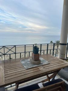 a wooden table with a cactus sitting on top of a beach at Pepe Beach Vista al Mar Apartment Estepona in Estepona