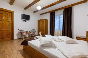 1 dormitorio con 2 camas y TV de pantalla plana en CONACUL DE SUB MUNTE, en Novaci-Străini