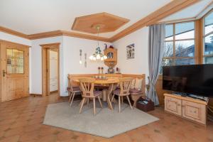 a dining room with a table and chairs and a television at Ferienwohnung Elisabeth in Reit im Winkl