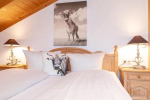 ライト・イム・ヴィンクルにあるFerienwohnung Elisabethのベッドルーム1室(枕に牛2頭を乗せたベッド1台付)
