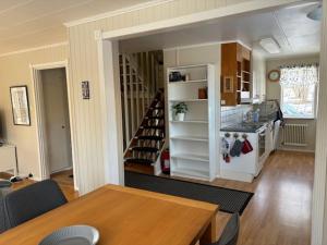 a kitchen and dining room with a table and a staircase at Familienfreundliches Schwedenhaus Fengersfors in Fengersfors