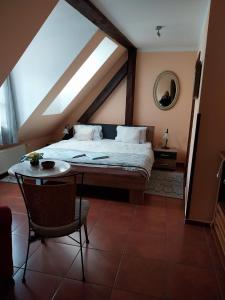 a attic bedroom with a bed and a table at Penzion Albatros in Český Krumlov