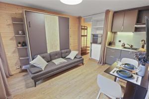 ein Wohnzimmer mit einem Sofa und einem Tisch in der Unterkunft Magnifique studio avec terrasse au centre in Crans-Montana