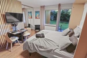 Schlafzimmer mit einem Bett, einem Schreibtisch und einem TV in der Unterkunft Magnifique studio avec terrasse au centre in Crans-Montana