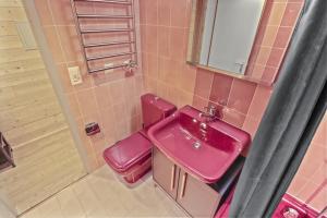ein rosafarbenes Bad mit einem Waschbecken und einem WC in der Unterkunft Magnifique studio avec terrasse au centre in Crans-Montana