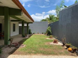 un patio trasero de una casa con césped en Casa Suiza – Schweizer Haus, en Liberia