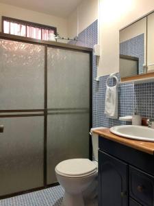 y baño con ducha, aseo y lavamanos. en Casa Suiza – Schweizer Haus, en Liberia
