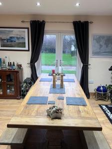 Awel Y Trydan في Llanon: غرفة مع طاولة خشبية مع حصيرة زرقاء
