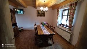 ein Esszimmer mit einem Holztisch mit Blumen darauf in der Unterkunft Jurajski Domek in Żarki