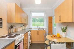 a kitchen with a table and a stove top oven at The View by Afan Valley Escapes in Port Talbot