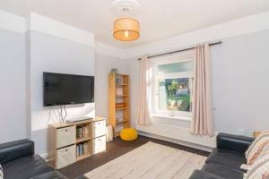 uma sala de estar com um sofá, uma televisão e uma janela em The View by Afan Valley Escapes em Port Talbot