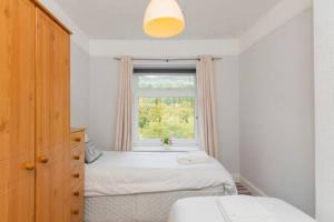 um pequeno quarto com uma cama e uma janela em The View by Afan Valley Escapes em Port Talbot