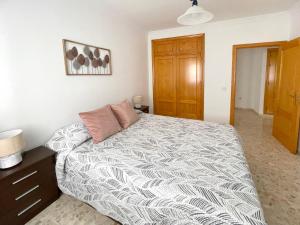 a bedroom with a large bed and a wooden cabinet at Casa playa Melosas- Torre del mar- HOME RENT MALAGA in Torre del Mar