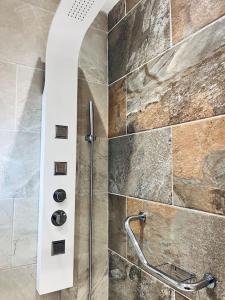 a shower in a bathroom with a stone wall at Daffodil Cottage in Cockermouth