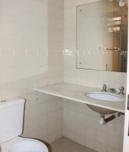 La salle de bains est pourvue d'un lavabo et de toilettes. dans l'établissement Optimum Plaza Hotel, à Monte Alto