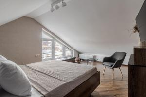 une chambre avec un lit, une chaise et une fenêtre dans l'établissement InshiApartments on Hazova str 6, à Lviv