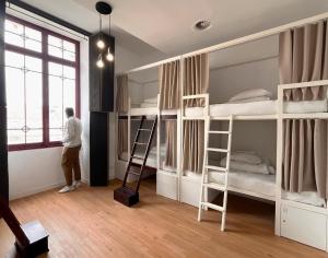 a man standing in a room with bunk beds at Lisbon Destination in Lisbon