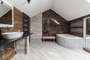 La salle de bains est pourvue d'une grande baignoire et d'un lavabo. dans l'établissement InshiApartments on Hazova str 6, à Lviv