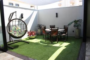 a room with a table and chairs on a green rug at Optimum Plaza Hotel in Monte Alto