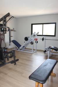 a gym with several tread machines in a room at Optimum Plaza Hotel in Monte Alto
