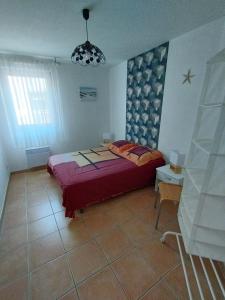 a bedroom with a bed and a table and a lamp at Amarine joli T3 Centre Ville terrasse parking et vélos in Sète