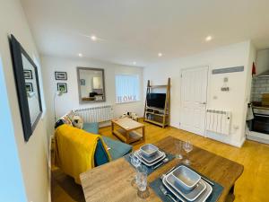 uma sala de estar com uma mesa e um sofá em Our Happy Place- 2 bedroom apartment with designated parking - Brixham em Brixham