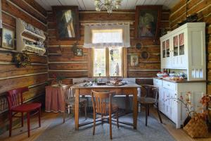 kuchnia z drewnianymi ścianami oraz stołem i krzesłami w obiekcie WsiaMać w mieście Odrzykoń