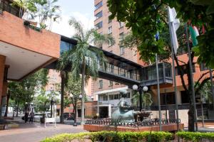 un edificio con una estatua delante de él en Hotel Dann Cali en Cali