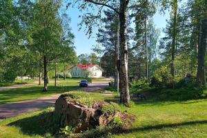 un tronco d'albero nell'erba vicino a una strada di Huoneisto 1 - 4 hengelle a Strömfors