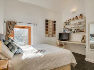 1 dormitorio con cama, escritorio y ventana en 2 Bed in Tiverton 77442 en Washfield