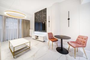 a living room with a table and two chairs and a tv at Hanza Tower Apartment no. 533 - 5th floor, balcony, swimming pool in Szczecin