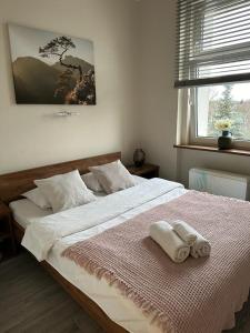 a bedroom with a large bed with two towels on it at Panama Apartament 1 Poznań in Poznań