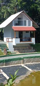 mały biały dom z werandą w obiekcie Chalé Lua Azul w mieście Jaraguá do Sul