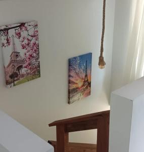 dwa obrazy na ścianie obok stołu w obiekcie Chalé Lua Azul w mieście Jaraguá do Sul