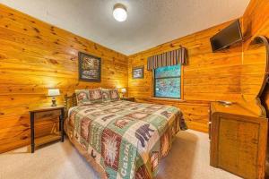 a bedroom with a bed and a television in a room at Lazy Creek Retreat in Gatlinburg