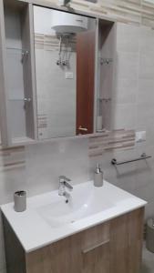 y baño con lavabo blanco y espejo. en La Difisola en Lizzano