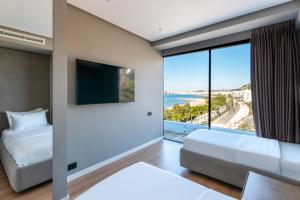 a bedroom with two beds and a large window at Yacht Hotel in Vlorë