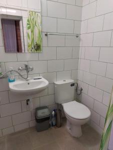 a white bathroom with a toilet and a sink at Студио Тони in Burgas