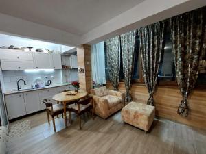 a kitchen and a dining room with a table and chairs at Студио Тони in Burgas