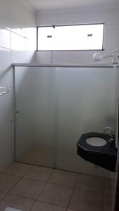 a bathroom with a sink and a toilet in a stall at Pousada Aquatur in Presidente Epitácio