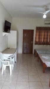 a room with a table and chairs and a door at Pousada Aquatur in Presidente Epitácio