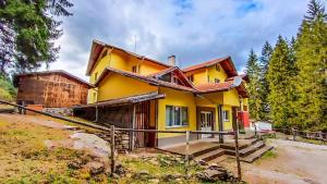 una casa amarilla en medio de un bosque en BUNGALOWS SKI PISTA Govedarci, en Govedartsi