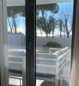 Vista mare Grado في غرادو: باب زجاجي منزلق مع إطلالة على الشاطئ