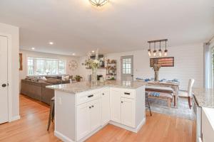a kitchen and living room with white cabinets and a table at Walk2Beach, HotTub, FirePit, PetsOk in Dennis