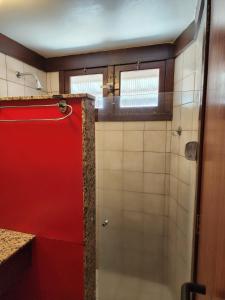 baño con cabina de ducha roja y puerta roja en Baia Cabralia Hotel, en Santa Cruz Cabrália