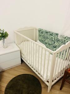 - un lit bébé blanc dans une chambre avec tapis dans l'établissement Large Garden, à Rome