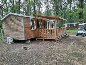 Cabaña de madera con cenador en un patio en Une petite chambre en forêt à Saint Chéron, en Saint-Chéron