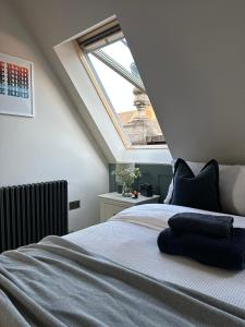 Schlafzimmer mit einem großen Bett und einem Dachfenster in der Unterkunft Central Warwick, Free Parking and Roof Terrace in Warwick